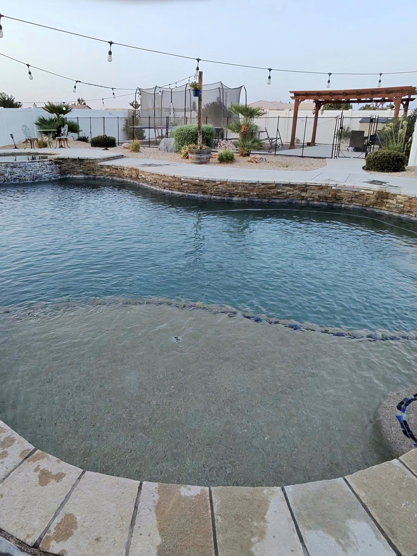 High Desert pool with tanning ledge at dusk